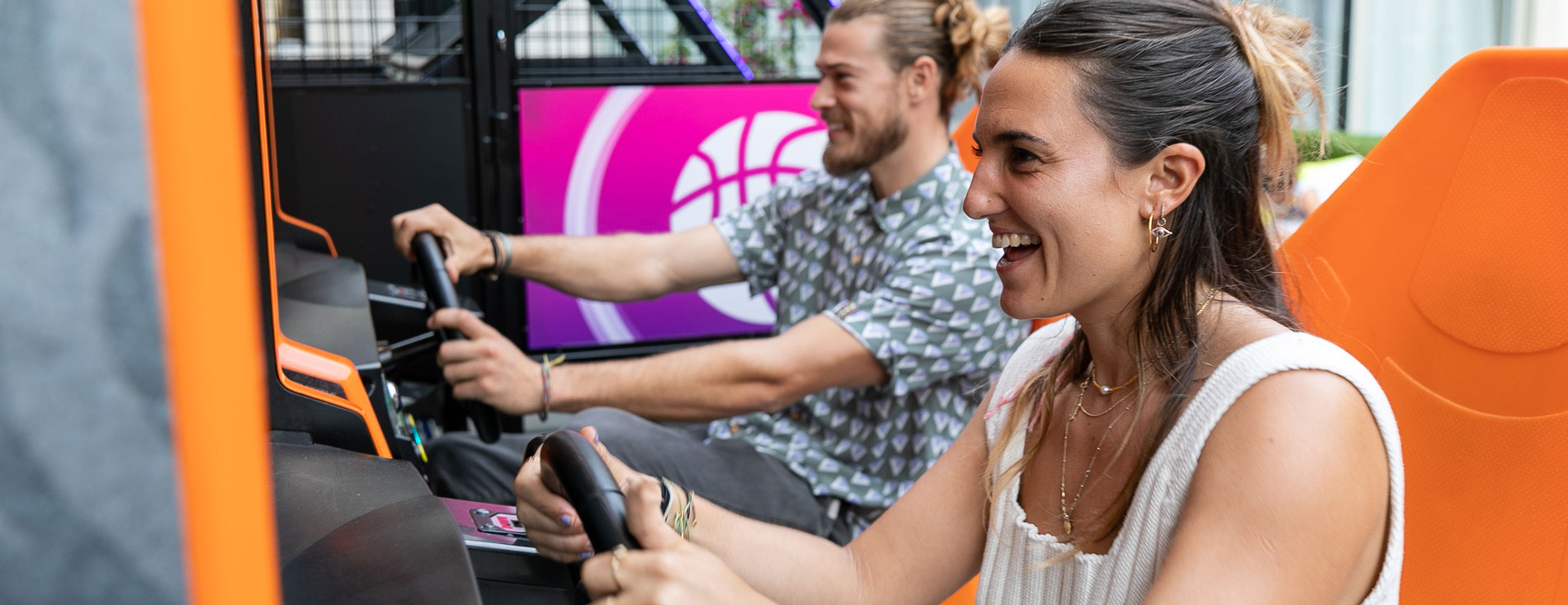 Young couple playing driving arcade game